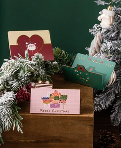 Detailed view of 3D folding Christmas greeting cards featuring Santa and festive wreaths