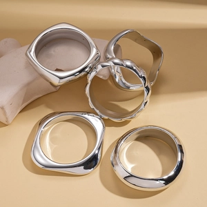Five-piece set of minimalist irregular geometric silver bangles in polished metal finish