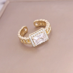 Close-up of gold ring featuring a rectangular zircon and micro-pave crystals