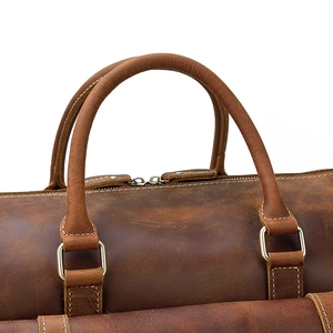 Close-up of vintage brown leather handles and sturdy metal hardware on travel bag