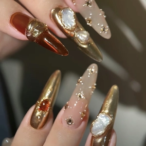 Luxury Baroque press-on nails with amber tones, pearls, and gold mirror finish details