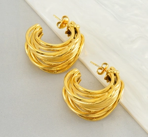 Detailed macro view of multi-layered gold curved earrings with irregular twisted metal lines
