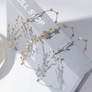 Sparkling crystal star and leaf headbands in gold and silver finish on gray background