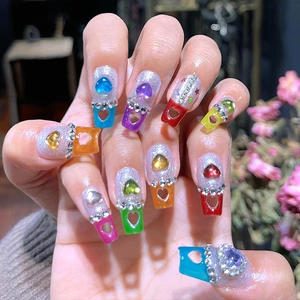 Coffin nail tips with hollow heart design and rhinestones in various colors