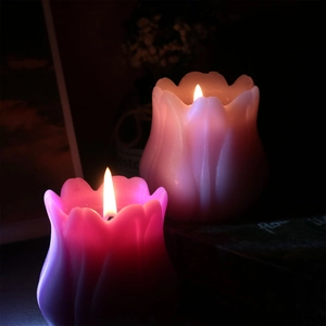 Dettaglio di candele profumate a forma di tulipano rosa con una luce morbida e romantica