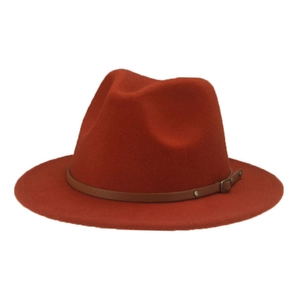 Detail view of the brown leather band and metallic buckle on a red felt fedora hat