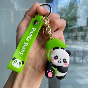 Close-up of cute panda keychain with green silicone strap and Panda Baby text detail