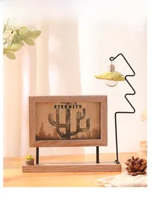 Detail of 6-inch rotating wooden photo frame with iron light stand and faux succulent decor