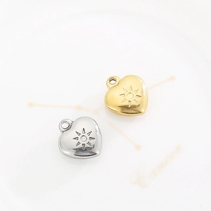 Golden and silver heart pendants with sun pattern engraving on a white background