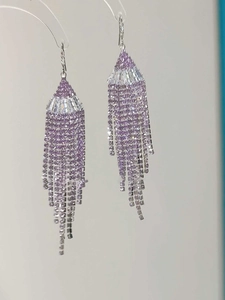 Macro view of long fan-shaped purple tassel earrings with sparkling cubic zirconia crystals