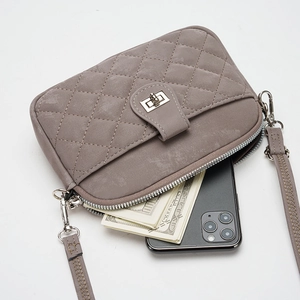 Taupe quilted crossbody phone bag with metal twist lock and detachable strap on white background