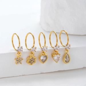 Set of gold hoop earrings with zircon pendants in heart, star, and flower shapes