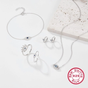 Flat lay of Evil Eye jewelry set in 925 sterling silver with blue and white crystals