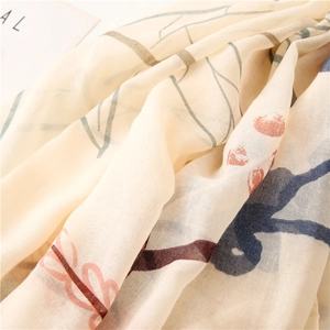 Macro shot of breathable beige cotton linen scarf with elegant floral and berry patterns
