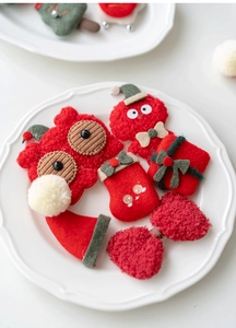 Detailed close-up of handmade felt Christmas ornaments including owl and gift box motifs
