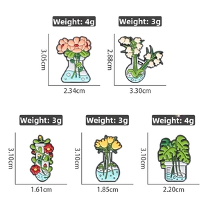 Makroansicht der Emaille-Pins mit Laborglas-Motiven und frischen Blumen-Designs