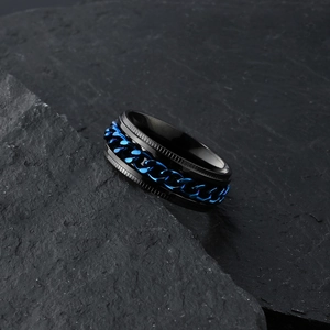 Macro shot of rotatable blue chain on black titanium steel ring set on dark rock