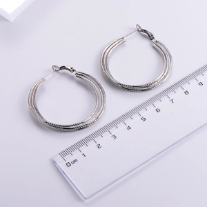 Detailed view of silver hoop earrings showing 4cm diameter size on a ruler scale