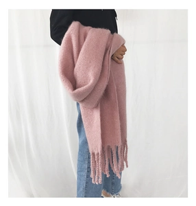 Close-up of thick pink cashmere-like scarf with chunky knit texture and soft fringe detail