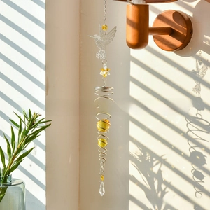 Detailed shot of hummingbird crystal suncatcher with spiral metal frame and amber beads