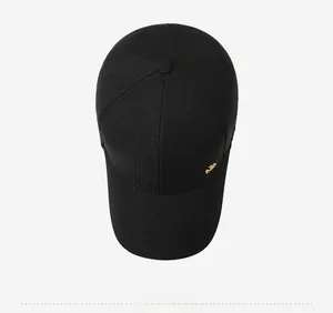 Close-up of black baseball cap showing textured fabric and gold metal side detail