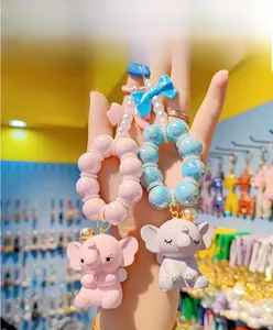Detail view of cute cartoon elephant keychains with crown, resin figurines and bows
