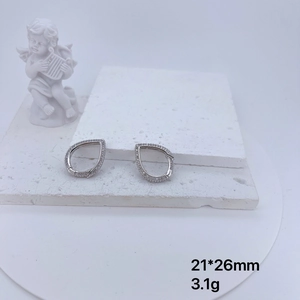Detail of teardrop earrings with white zircon micro-pave setting on stone backdrop
