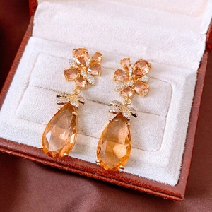 Détail macro des boucles d'oreilles vintage avec pendentifs en zircone champagne