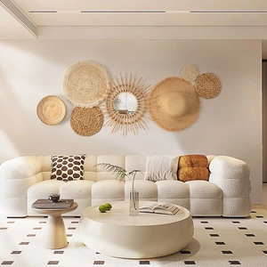 Detail of natural woven straw wall decor set with mirror and textured plates in a living room