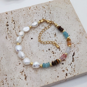 Detailed top view of baroque pearl and gemstone beaded bracelet on stone background