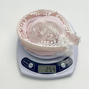 Pink seersucker lace headband with crochet edges and 3D details shown on a scale weighing 25.4g