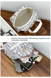 Detailed internal view of small faux leather snake print backpack showing storage capacity