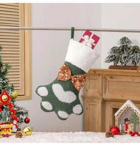 Détail d'une chaussette de Noël en tricot patte verte et blanche avec nœud à pois orange
