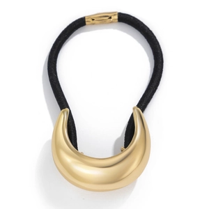 Macro detail of a minimalist golden curved metal buckle on a black elastic hair tie