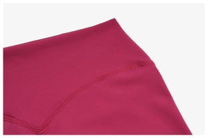 Macro detail of high-waisted yoga shorts in vibrant pink with flatlock stitching