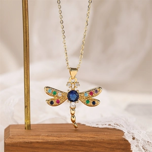 Detailed view of dragonfly pendant with multicolored gemstones and deep blue center stone
