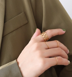 Close-up of a 4-piece gold ring set featuring a wide geometric band and three slim rings