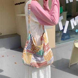 Detailed side view of large canvas tote bag with vibrant abstract colored stripes
