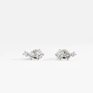 Macro shot of silver S925 earrings with sparkling geometric zircon stones on white background