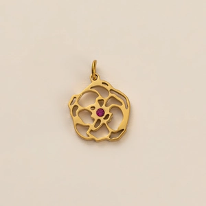 Détail d'un pendentif fleur dorée avec pétales évidés et pierre précieuse rose centrale