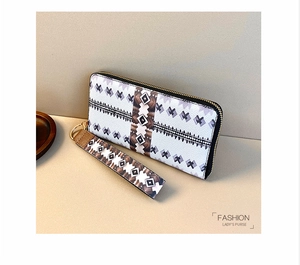 Detail of fashion lady's purse with geometric pattern print and gold zipper wristlet