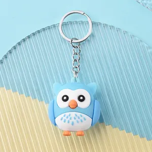 Detail shot of cute blue and white owl keychain made of soft PVC with silver metal ring