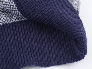 Macro shot of navy blue ribbed cuff and diamond pattern jacquard knit texture