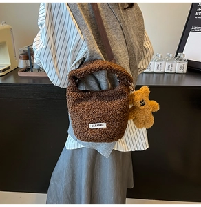 Détail du sac seau en polaire marron foncé avec breloque ours et étiquette brodée