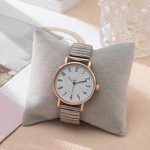 Detail of silver and rose gold stretch metal watch band on a display pillow