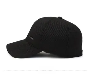 Detailed side view of black ribbed winter baseball cap with silver mountain metal emblem