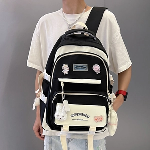 Black and white nylon backpack with cartoon pins and plush rabbit shown on model
