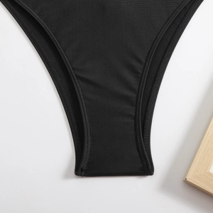 Detailed close-up of high-cut bikini bottom stitching and smooth black stretch fabric