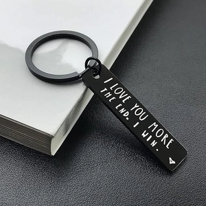 Macro detail of black stainless steel bar keychain with I Love You More engraving