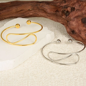 Detailed view of 18K gold and silver plated 304 stainless steel open cuffs with ball ends
